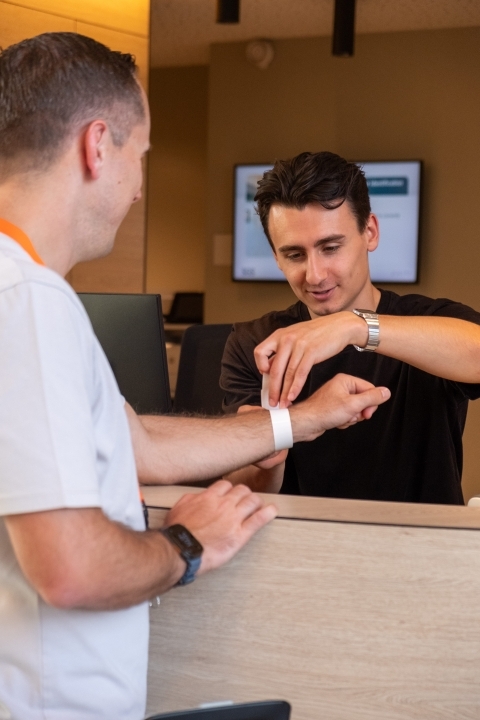 Vrijwilliger start aan studie en krijgt armband aan onthaal van cpu edegem